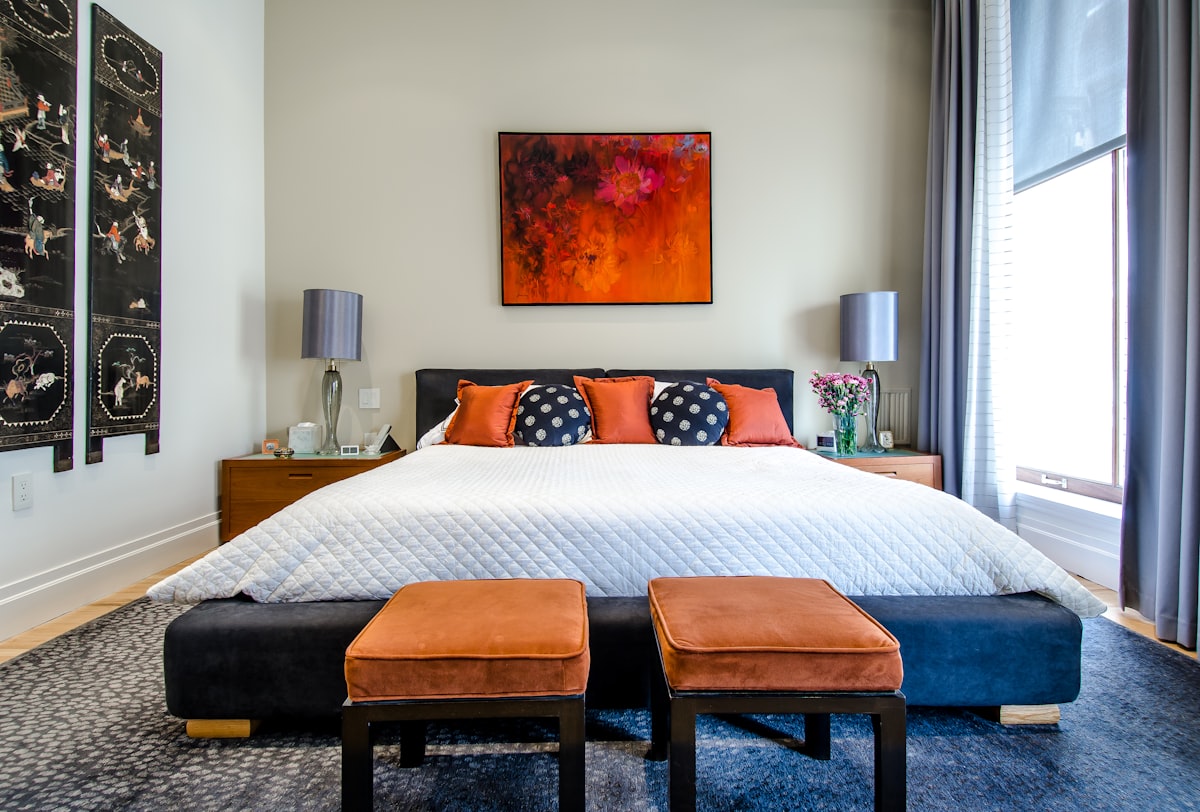 Airbnb bedroom interior design Dubai with layered bedding and warm accents